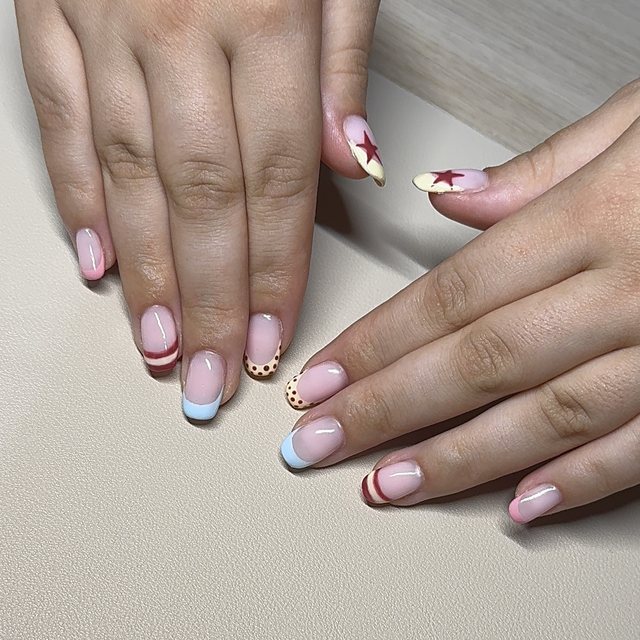 Pale blue, pink and red French tips with dots, stripes and red stars